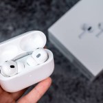 Jurmala, Latvia - 21 09 2023: In a womans hand there is open case with headphones - AirPods Pro 2 generation. On background Apple headphones box. High quality photo