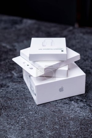 Foto de Jurmala, Letonia - 21 09 2023: Cuatro cajas blancas de dispositivos Apple están en una pila. Primer unboxing: AirPods Pro 2, MagSafe Charger, AirTag, adaptador de Lightning a Headphone Jack. Foto de alta calidad - Imagen libre de derechos