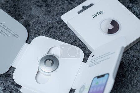 Téléchargez les photos : Jurmala, Lettonie - 21 09 2023 : boîtes blanches avec gadget pour suivre vos affaires - AirTag Apple. Nouveau Air Tag dans le film sur la boîte. . Photo de haute qualité - en image libre de droit