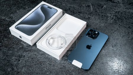 Foto de Jurmala, Letonia - 30 11 2023: unboxing of new smarphone apple iPhone 15 Pro Max in Blue Titanium color on grey table. Foto de alta calidad - Imagen libre de derechos