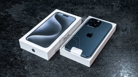 Téléchargez les photos : Jurmala, Lettonie - 30 11 2023 : Boite et nouveau smartphone Apple iPhone 15 Pro Max en couleur Titane Bleu sur table grise. Photo de haute qualité - en image libre de droit