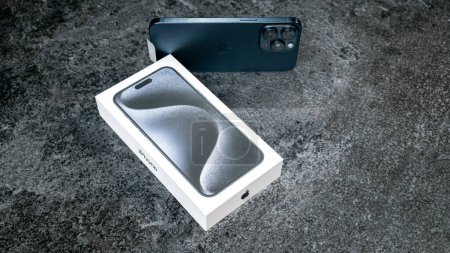 Photo for Jurmala, Latvia - 30 11 2023: Box and new smarphone apple iPhone 15 Pro Max in Blue Titanium color on grey background. High quality photo - Royalty Free Image