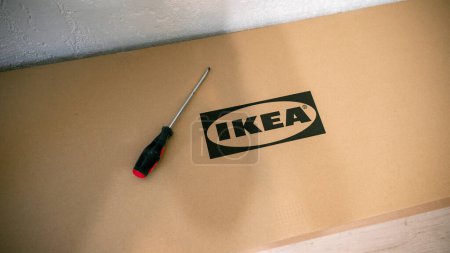 Téléchargez les photos : Jurmala, Lettonie - 18 02 2024 : Une boîte de meubles Ikea et un tournevis pour assembler les meubles. . Photo de haute qualité - en image libre de droit