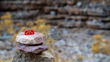 Red dice on a tower of stones. Concept of chance and victory. High quality photo