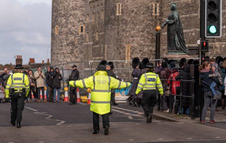 Foto de Windsor, Berkshire, Inglaterra, Reino Unido. 2023. Guardián ceremonial controlando a la multitud con los brazos extendidos durante la ceremonia de cambio de guardia. - Imagen libre de derechos