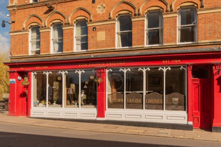Téléchargez les photos : Eton, Buckinghamshire, Angleterre, RU. 2023. Célèbre boutique de tailleur peinte en rouge et blanc sur High Street Eton - en image libre de droit