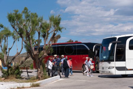 Téléchargez les photos : Elounda, Crète, Grèce. 2023. Les voyageurs attendent pour monter à bord de leur bus touristique à la gare routière d'Elounda un resrt côtier populaire en Crète - en image libre de droit