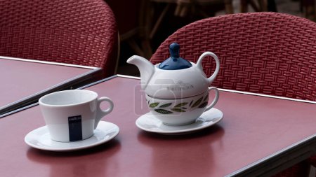 Photo for France, Europe. 2023.  Tea cup and teapot with a coffee cup on a cafe table outside. - Royalty Free Image