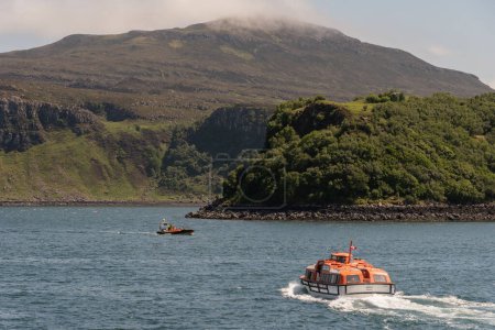 Photo for Portree, Isle of Skye, Scotland, UK. 5 June 2023. Cruise ship tender underway on Loch Portree outbound with passengers to rejoin their ship - Royalty Free Image