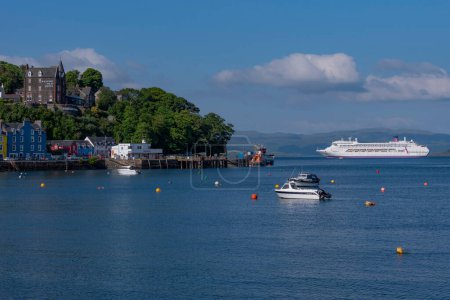 Photo for Tobermory, Isle of Mull, Scotland, UK.  6 June 2023.  Cruise ship anchored on the Sound of Mull beyond the coastal town of Tobermory. - Royalty Free Image