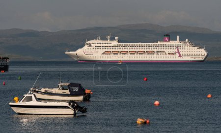 Photo for Tobermory, Isle of  Mull, Scotland, UK. 6 June 2023.  Looking out from Tobermory across the Sound of Mull are some small leisure boats and  a cruise ship at anchor. - Royalty Free Image