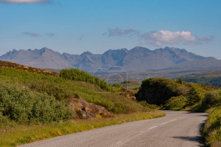 Photo for Isle of Skye,  Scotland, UK.  5 June 2023. Open road and scenic countryside view across to the Cuillin Hills with a blue sky. Isle of Skye, UK. - Royalty Free Image