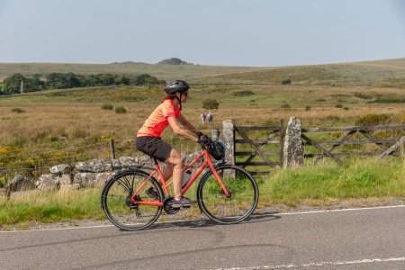 Photo for Dartmoor, Devon, England, UK. 4 September 2023. Woman cyclist on a cycle tour on Dartmoor national park, Devon, England, UK. - Royalty Free Image