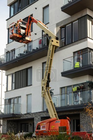 Photo for Plymouth, Devon, England,UK. 06.09.2023. Property maintenance by a cherry picker extended on the exterior of a building complex in Plymouth. - Royalty Free Image