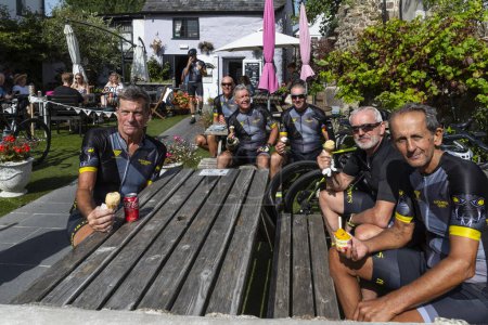 Photo for Moretonhampstead, Devon, England, UK. 05.09.2023. A group of cyclists eating ice cream in a cafe garden at Moretonhampstead on Dartmoor, Devon. - Royalty Free Image