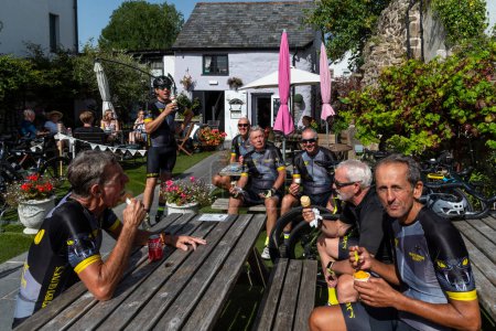 Photo for Moretonhampstead, Devon, England, UK. 05.09.2023. A group of cyclists eating ice cream in a cafe garden at Moretonhampstead on Dartmoor, Devon. - Royalty Free Image