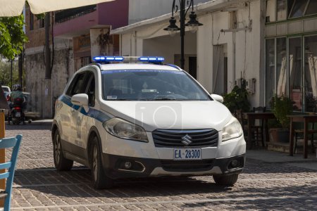Photo for Mohos, Lasithi district, Crete, Greece.  30.09.2023.  Greek police car on blue light driving through small town on narrow street. - Royalty Free Image