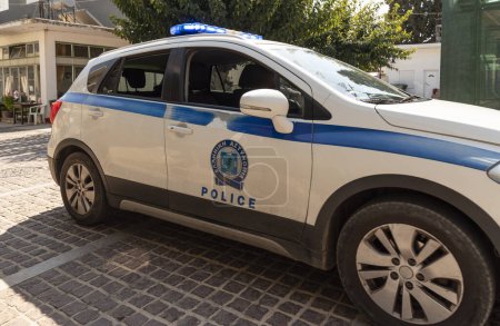 Foto de Mohos, distrito de Lasithi, Creta, Grecia. 30.09.2023. Coche de policía griego en la luz azul que conduce a través de la pequeña ciudad en la calle estrecha. - Imagen libre de derechos