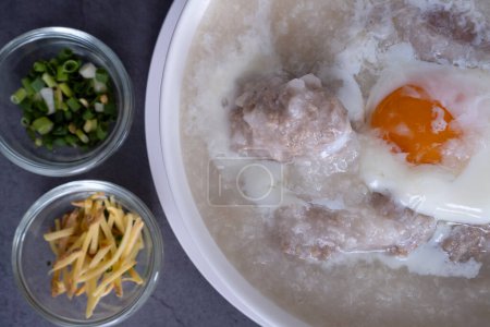 Hot Thai congee (rice porridge) with minced pork ball and boiled egg as breakfast