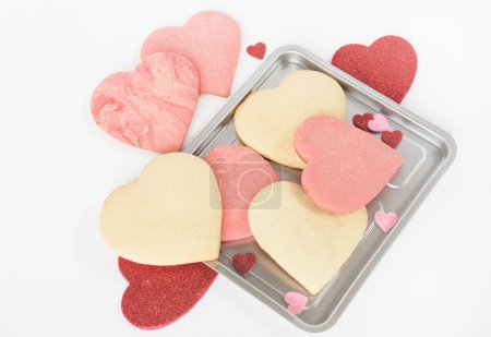 Photo for Unfrosted Baked Valentine Sugar Cookies with Glitter Hearts - Royalty Free Image