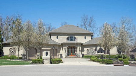 Photo for Palatial Luxury Home in Gray Stucco with Flowering Pear Trees - Royalty Free Image