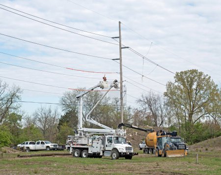 Foto de Dayton, Ohio - 4 de mayo de 2023: Trabajadores eléctricos instalan un nuevo poste eléctrico como parte del desarrollo del terreno para un nuevo complejo de condominios. - Imagen libre de derechos