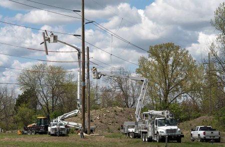 Foto de Dayton, Ohio - 4 de mayo de 2023: Trabajadores eléctricos instalan un nuevo poste eléctrico como parte del desarrollo del terreno para un nuevo complejo de condominios. - Imagen libre de derechos