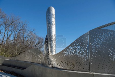Foto de Kettering, Ohio, Estados Unidos - 16 de noviembre de 2023: FOLIAGE stainless steel sculpture by Cliff Garten Studio (Venice, CA), comisionado por City of Kettering para integrar el paisaje de Hills & Dales MetroPark y Kettering en el nuevo Ridgeway Rd Bridge. - Imagen libre de derechos