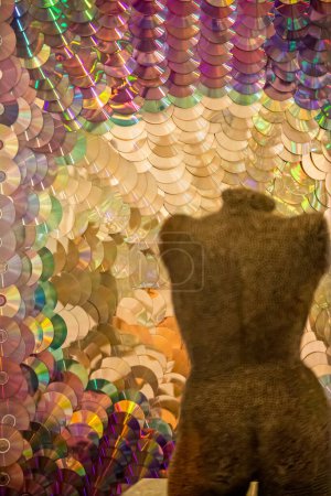 Téléchargez les photos : Mannequin sculpture with background of colorful CD discs - en image libre de droit