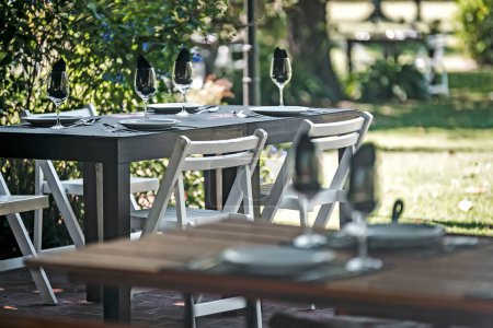 Téléchargez les photos : Tables et chaises dans un jardin ensoleillé - en image libre de droit