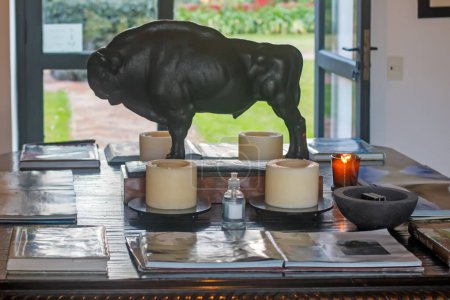 Foto de Un primer plano de una vela y una escultura de toro sobre una mesa - Imagen libre de derechos
