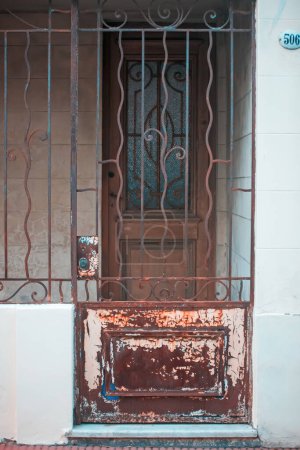 Foto de Una puerta con una puerta de hierro oxidado y una pared de ladrillo - Imagen libre de derechos