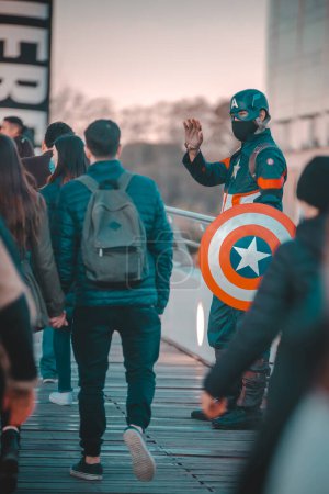 Téléchargez les photos : Homme porter costume de héros agitant la main aux gens - en image libre de droit