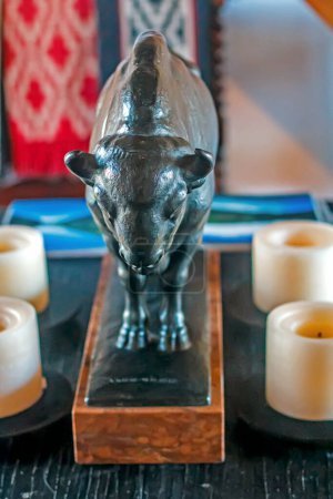 Photo for A closeup shot of a candles and bull sculpture on a table - Royalty Free Image