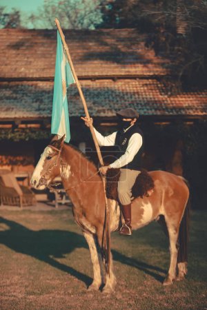 Foto de BUENOS AIRES, ARGENTINA - 13 de abril de 2022: Hombre a caballo con bandera - Imagen libre de derechos