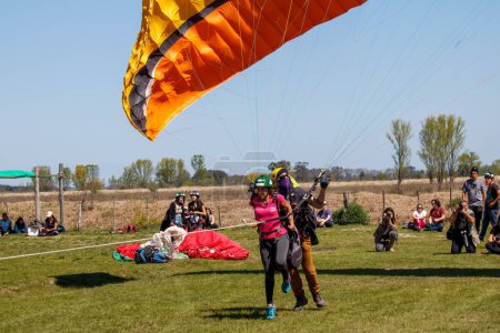 Téléchargez les photos : Couple tenant un parachute debout dans un champ - en image libre de droit