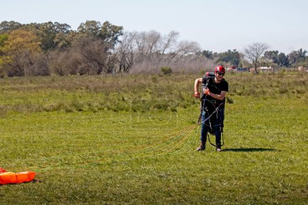 Foto de Hombre tirando de un paracaídas en un campo - Imagen libre de derechos