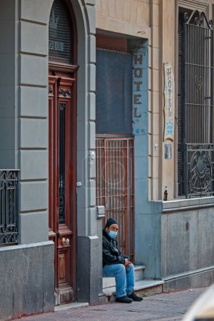 Foto de Hombre sentado en las escaleras frente a un hotel - Imagen libre de derechos