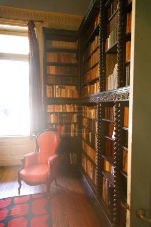 Photo for Chair in a library with a window - Royalty Free Image