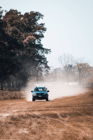 Téléchargez les photos : Une voiture conduisant sur un chemin de terre avec des arbres en arrière-plan - en image libre de droit