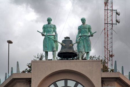 Téléchargez les photos : Tour de l'horloge avec une statue de deux hommes sur le dessus - en image libre de droit
