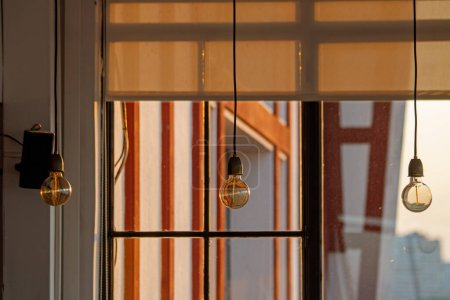 Foto de Lámpara moderna con techo de madera y lámpara de vidrio en la ventana por la mañana. - Imagen libre de derechos
