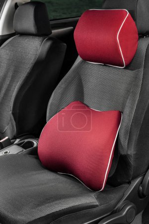 Foto de Una almohada suave para la parte inferior de la espalda y el cuello en el coche. Dispositivos ortopédicos en el coche. Significa para la salud del conductor. Una almohada en el asiento del conductor. - Imagen libre de derechos