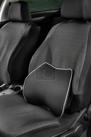 Foto de Una almohada suave para la parte inferior de la espalda y el cuello en el coche. Dispositivos ortopédicos en el coche. Significa para la salud del conductor. Una almohada en el asiento del conductor. - Imagen libre de derechos