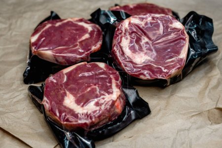 Photo for Fresh beef in vacuum packaging on a background of kraft paper - Royalty Free Image