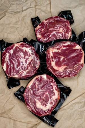 Photo for Fresh beef in vacuum packaging on a background of kraft paper - Royalty Free Image