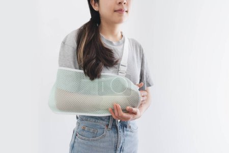 Téléchargez les photos : Jeune femme blessée à la main portant une attelle, bras cassé, isolée sur fond blanc - en image libre de droit