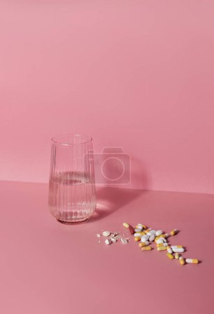 Photo for Glass of water and bunch of pills on a table. Well-being and medicine concept - Royalty Free Image