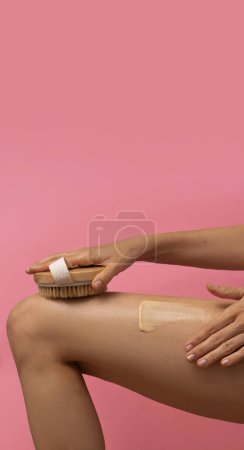 Photo for Woman dry-brushing her body on ponk background, beauty concept - Royalty Free Image