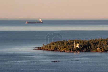 Photo for A high angle telephoto shot of a lake superior laker passing the copper harbor lighthouse on the keeweenaw peninsula of michigan - Royalty Free Image